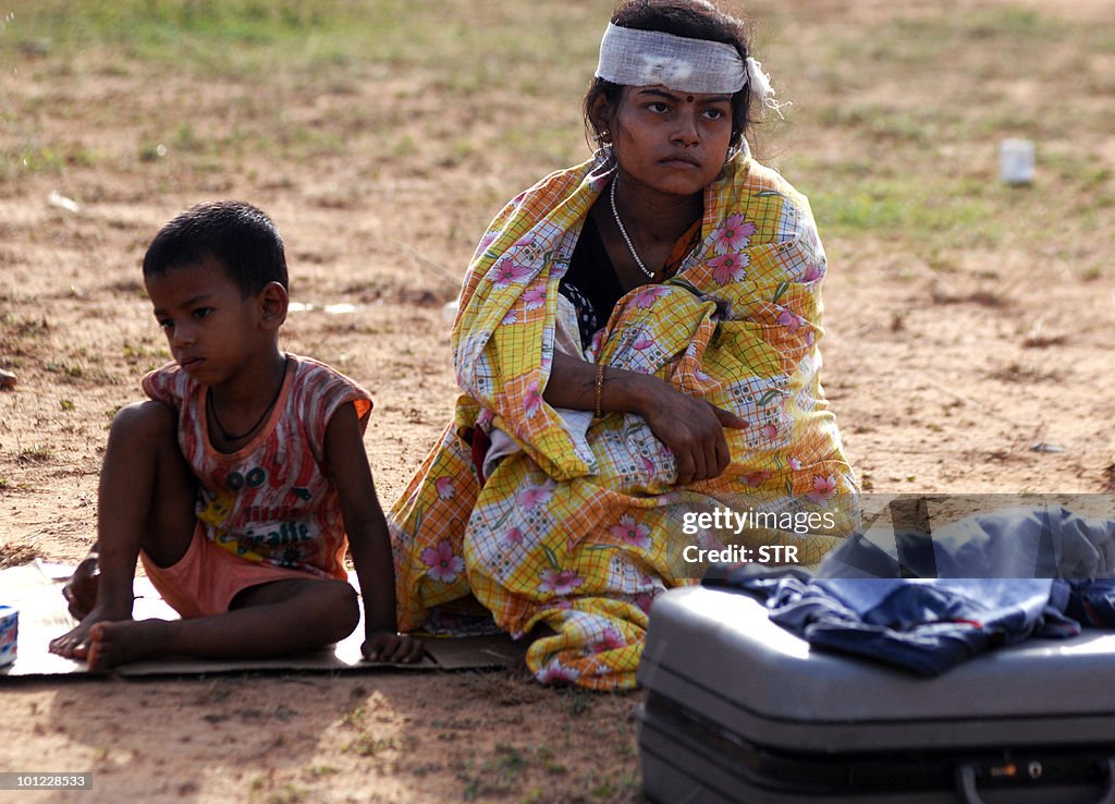 An injured woman and a child sit by the