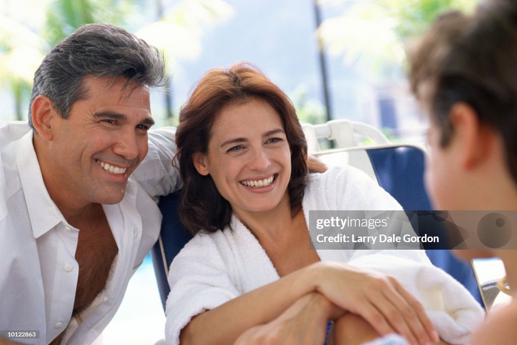 HISPANIC COUPLE AGE 40 TO 50 ON HOLIDAY AT HOTEL POOL