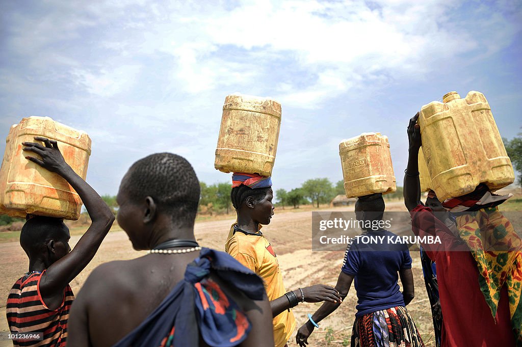 South Sudanese women carry jerry-cans fi