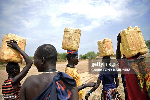 South Sudanese women carry jerry-cans filled with water on their heads on April 2 at Terekeka, 82 km north of Juba, an area where the population is...