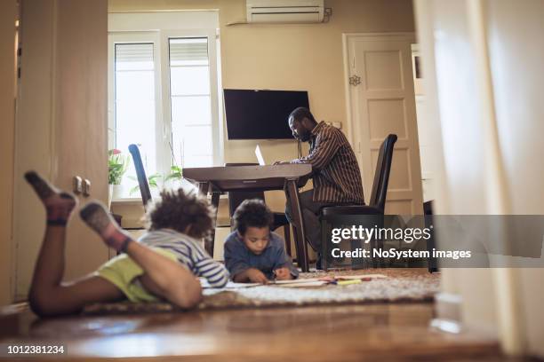 kids playing while their father working at home - freelance child stock pictures, royalty-free photos & images