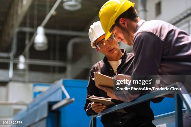 factory workers discussing with each other in factory - selective focus stock pictures, royalty-free photos & images