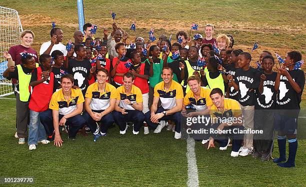 Mark Milligan, James Holland,Luke Wiltshire, Mark Schwarzer,David Carney and Tom Oar pose with local school children at a soccer clinic after an...