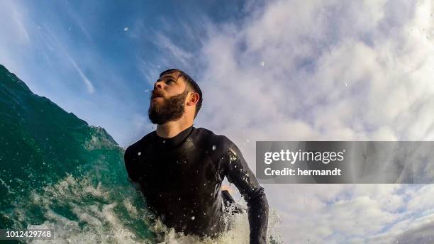 surfer catching a wave, camps bay, western cape, south africa - camps bay stock pictures, royalty-free photos & images