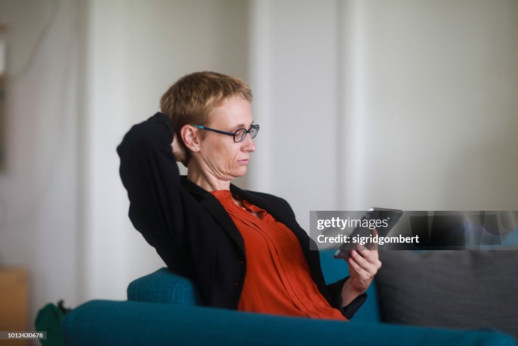 Woman sitting on a couch using a digital tablet