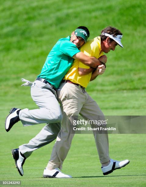 Alvaro Quiros holds onto playing partner and country man Gonzalo Fernandez - Castano of Spain during the second round of the Madrid Masters at Real...