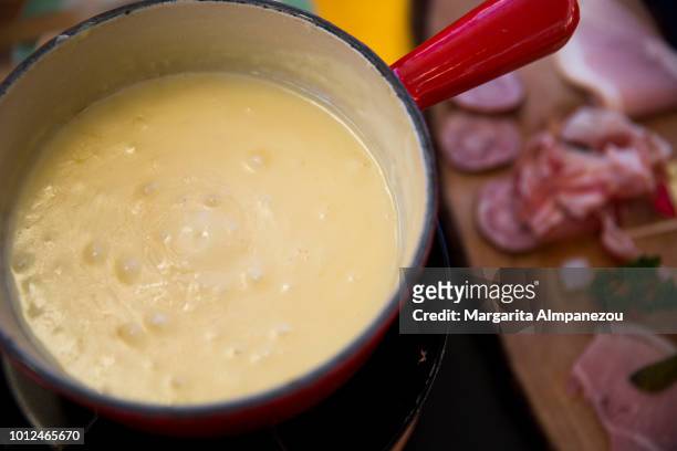 gruyere cheese melted in fondue - fondue stock-fotos und bilder