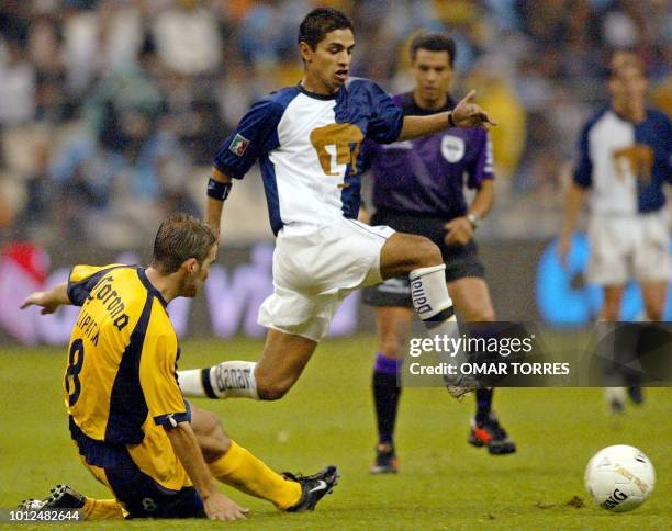 Marcelo Lapitan of the America team tries to stop Mariano Trujillo of the Pumas team from advancing with the ball, 14 May 2002, during the semi...