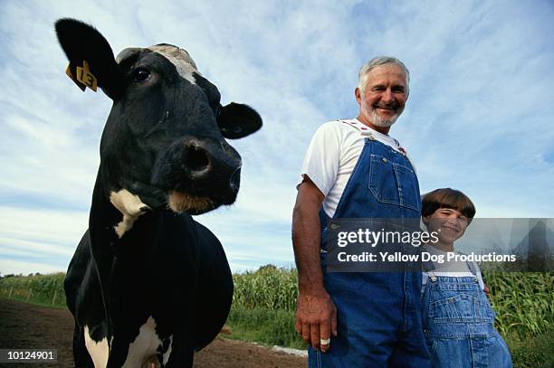 grandfather and grandson on dairy farm - rancher photos et images de collection