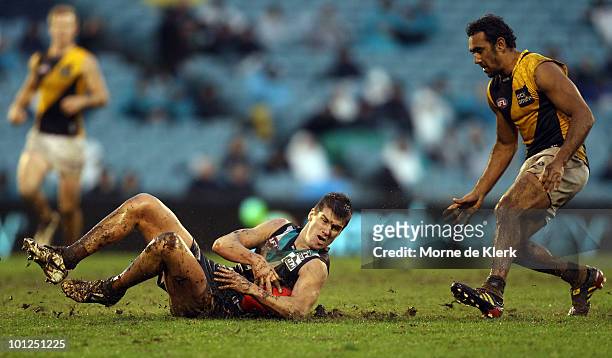 Paul Stewart of the Power slides on the ground in front of Richard Tambling of the Tigers during the round 10 AFL match between Port Adelaide Power...