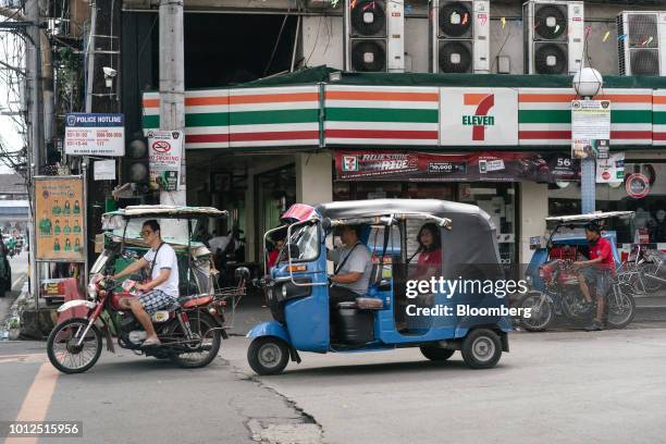 Tricycle and motorcyclist pass in front of a 7-eleven store in Manila, Philippines, on Monday, Aug. 6, 2018. Consumer prices in the Philippines...