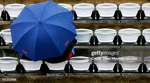 Fans brave the weather with their umbrellas as rain falls during day 3 of the 1st npower Test between England and Bangladesh played at Lords on May...