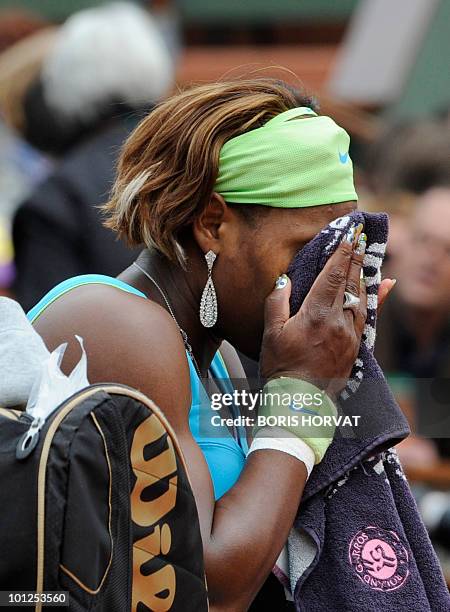 Serena Williams wipes her face during her women's third round match against Russia's Anastasia Pavlyuchenko in the French Open tennis championship at...