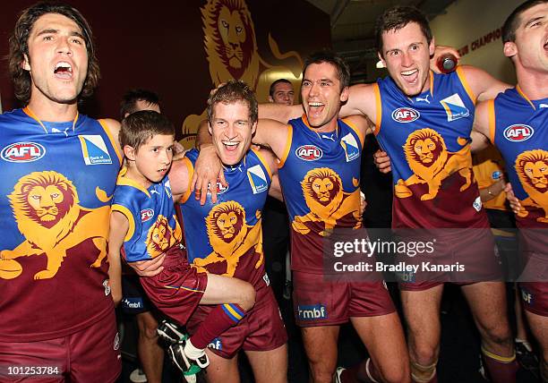 Luke Power celebrates victory with his son and his team mates after the round 10 AFL match between the Brisbane Lions and the Collingwood Magpies at...