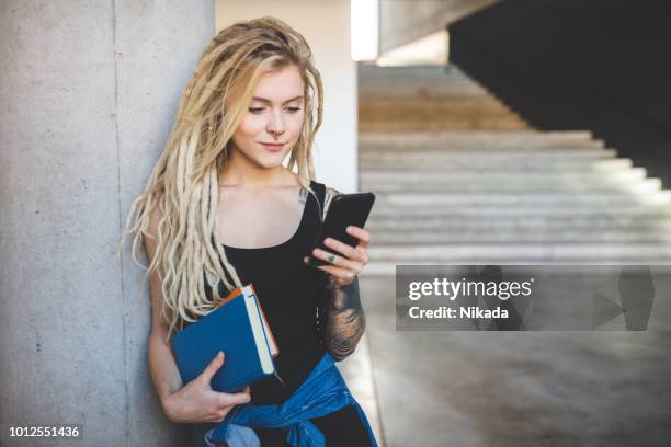 mujer con rastas con teléfono en la universidad de - dreadlocks fotografías e imágenes de stock