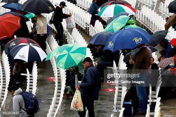 Fan with a Brit Insurance umbrella braves the weather as rain falls during day 3 of the 1st npower Test between England and Bangladesh played at...