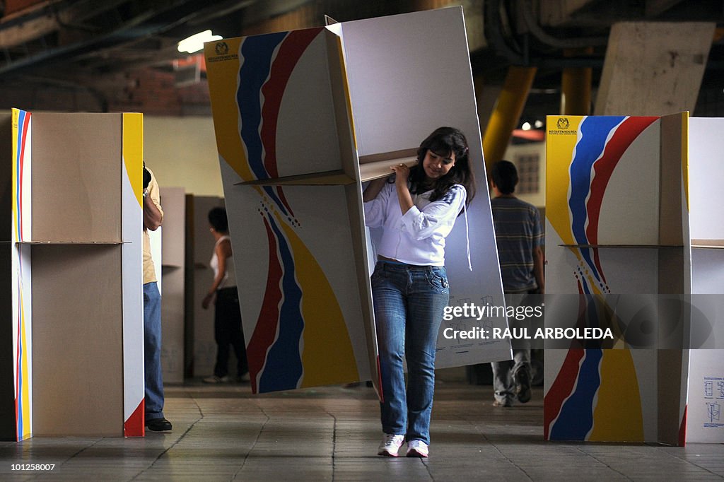 A worker carries a voting booth at a pol