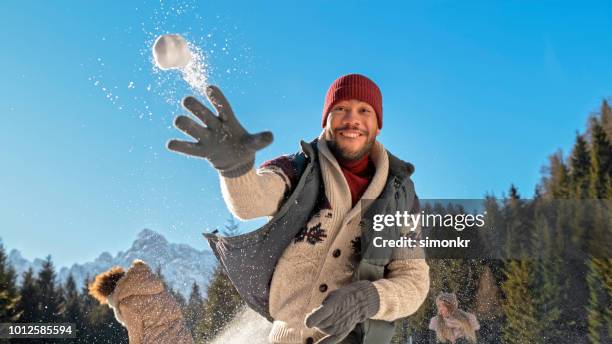 mann werfen schneeball - schneeball stock-fotos und bilder