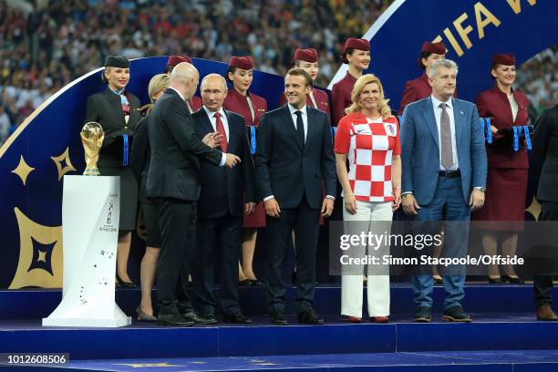 President Gianni Infantino stands on stage next to the trophy alongside Russian President Vladimir Putin , French President Emmanuel Macron ,...