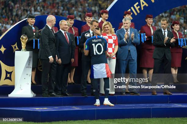 President Gianni Infantino stands on stage next to the trophy alongside Russian President Vladimir Putin , Croatian President Kolinda...