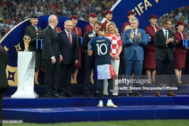 President Gianni Infantino stands on stage next to the trophy alongside Russian President Vladimir Putin , Croatian President Kolinda...
