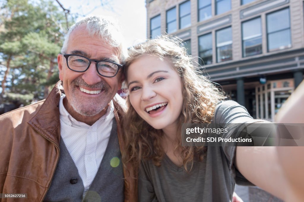 Teenager-Mädchen nimmt Selfie mit Großvater