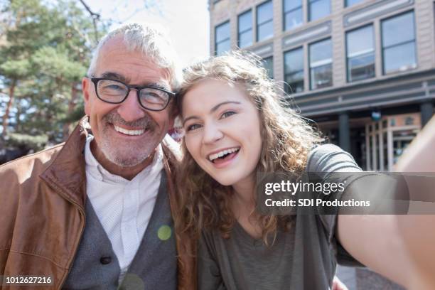 teenage girl takes selfie with grandfather - co op city stock pictures, royalty-free photos & images