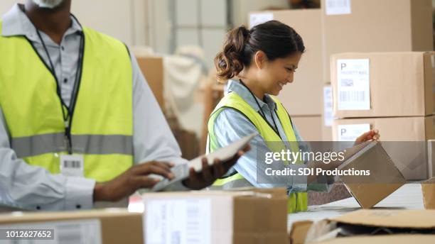 distribution warehouse employees prepare packages for shipment - storage room boxes stock pictures, royalty-free photos & images