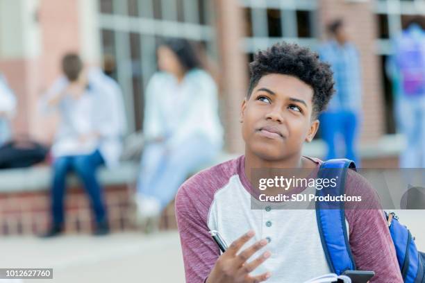 tiener werkt hard op huiswerkopdracht - boy thinking stockfoto's en -beelden