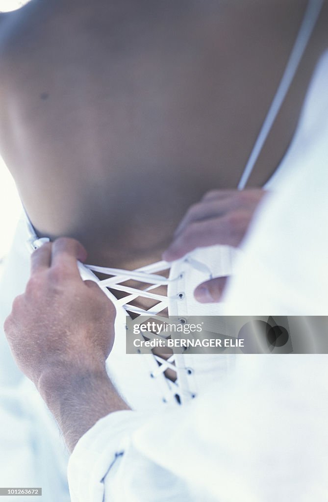 Man tying corset