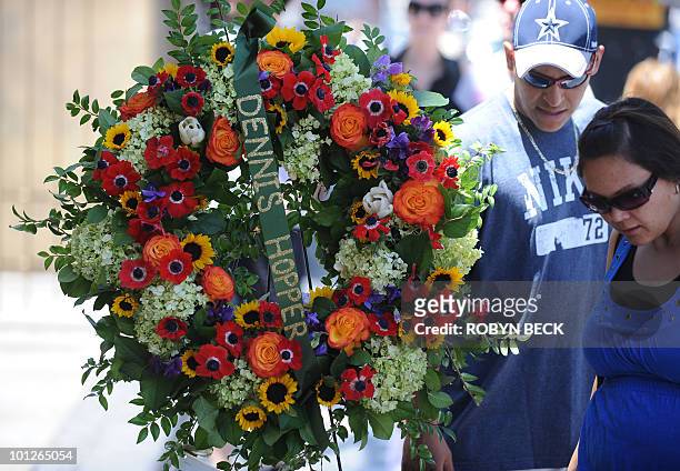 People gather around the star of actor Dennis Hopper where a wreath was placed following news of his death, on the Hollywood Walk of Fame in the...
