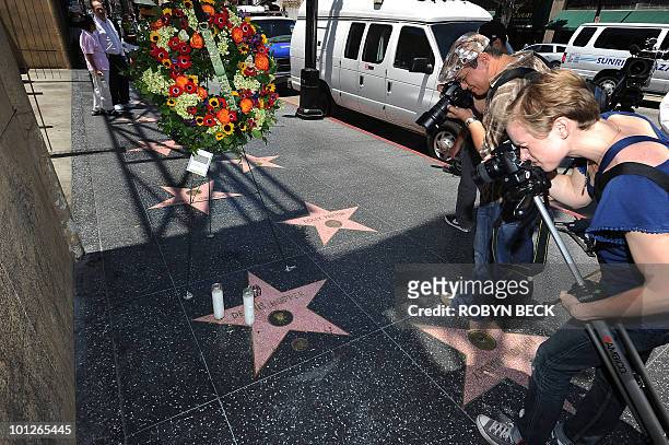 People take photographs of the star of actor Dennis Hopper where a wreath was placed following news of his death, on the Hollywood Walk of Fame in...
