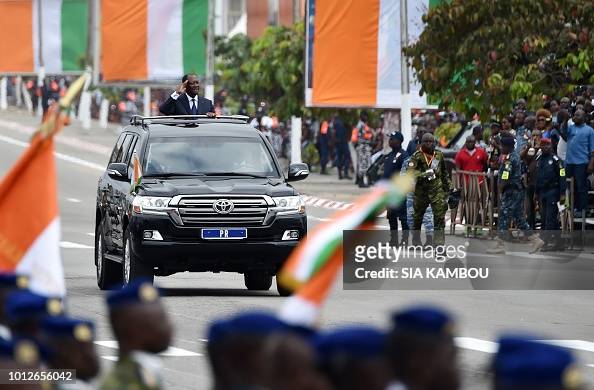 Ivory Coast's President Alassane Ouattara salutes from his car during ...