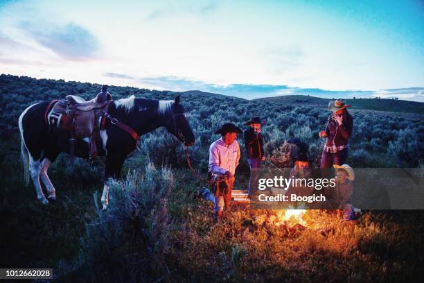 mature american cowboy tells ghost stories to children by campfire in utah usa - campfire storytelling stock pictures, royalty-free photos & images