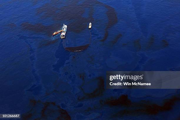 Crews on ships work on skimming and collecting oil near the source site of the Deepwater Horizon disaster May 29, 2010 in the Gulf of Mexico near...