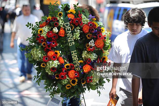 People walk by the star of actor Dennis Hopper where a wreath was placed following news of his death, on the Hollywood Walk of Fame in the Hollywood...