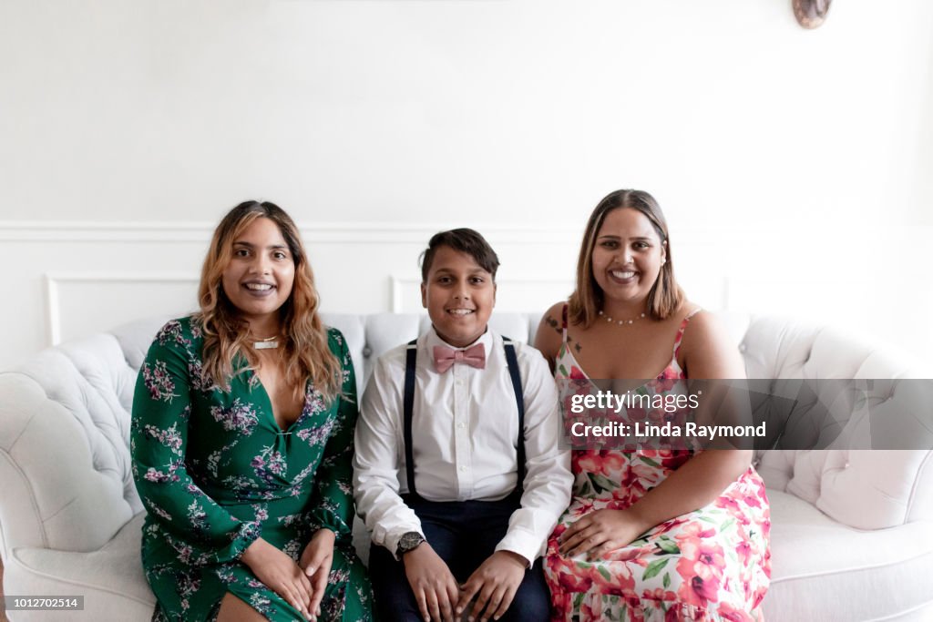 Portrait of three indian brother and sister sitting on a sofa