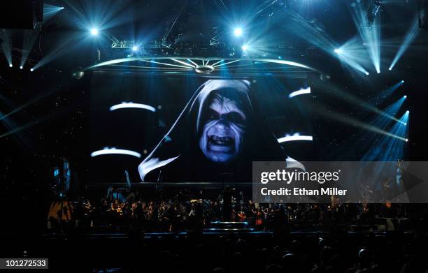 Actor Ian McDiarmid's Emperor Palpatine character from the Star Wars series of films is shown on screen while musicians perform during "Star Wars: In...