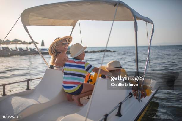 mother and two sons on a pedal boat - paddleboat stock pictures, royalty-free photos & images