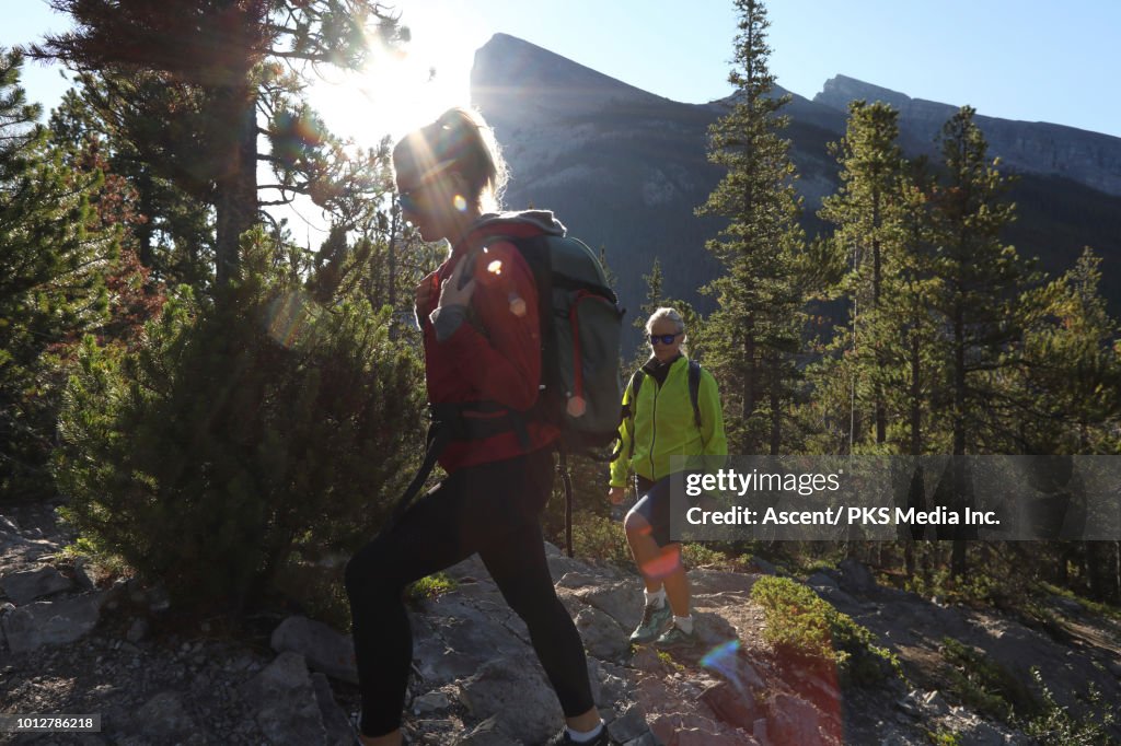 Mother and daughter hike along mountain ridge