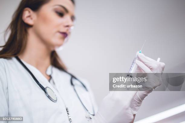 medico donna che tiene la siringa con la medicina. - squirting foto e immagini stock