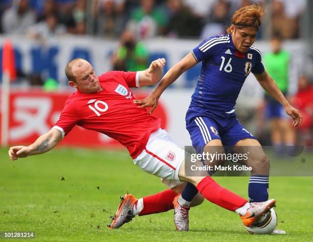 Wayne Rooney of England tackles Yoshito Okubo of Japan during the International Friendly between Japan and England at UPC-Arena on May 30, 2010 in...