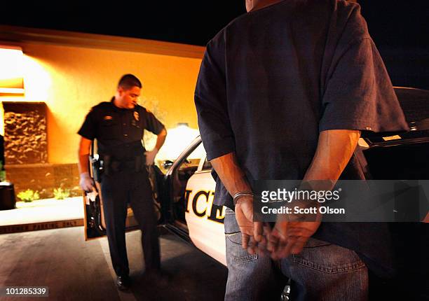 Tucson Police Officer Angel Ramirez arrests a man for trespassing May 29, 2010 in Tucson, Arizona. Ramirez works in the city's predominately Hispanic...