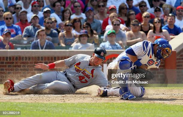 Ryan Ludwick of the St. Louis Cardinals scores a seventh inning run past Geovany Soto of the Chicago Cubs on May 30, 2010 at Wrigley Field in...
