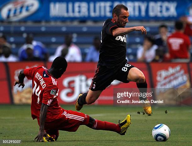 Cristian Brocci of AC Milan jumps in the air to move the ball past Patrick Nyarko of the Chicago Fire in the first half during an international...