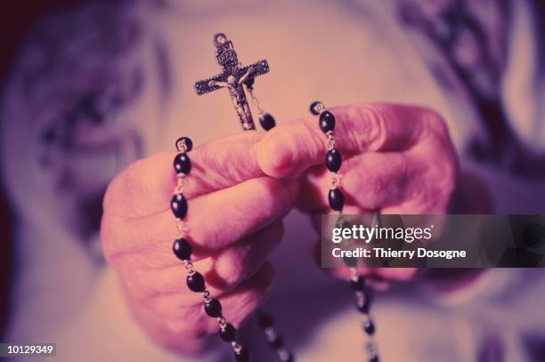 close up of hands with rosary - monja fotografías e imágenes de stock