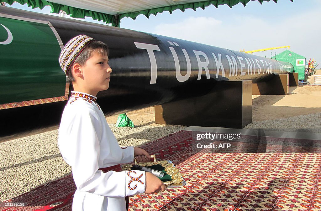 A Turkmen boy in traditional dress waits