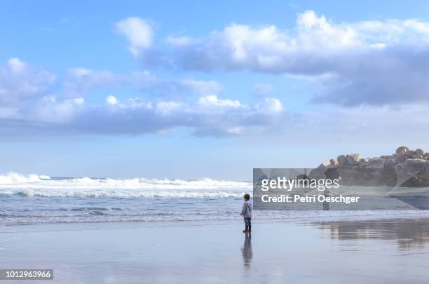 family on winter beach.(boy standing) - llandudno stock-fotos und bilder