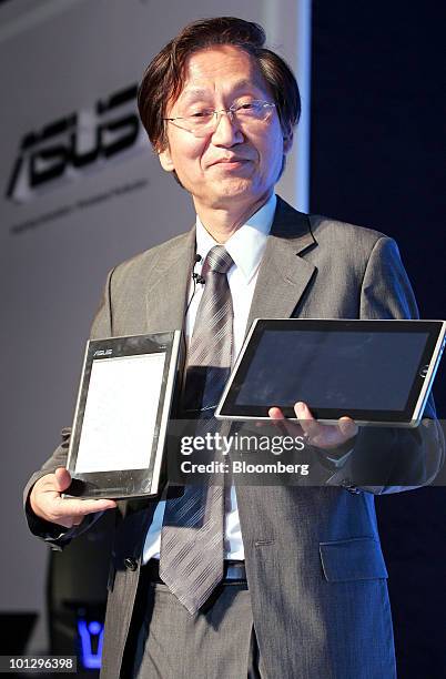 Jonney Shih, chairman of Asustek Computer Inc., poses for a photograph with the company's new Eee Pad netbook, right, and Eee Tablet e-reader, during...