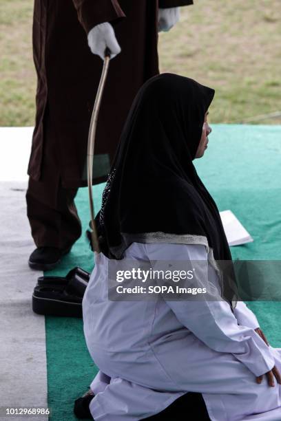 Woman seen being whipped on the public stage. Four people were convicted by the Lhokseumawe Sharia Court of various crimes and flogged in front of...